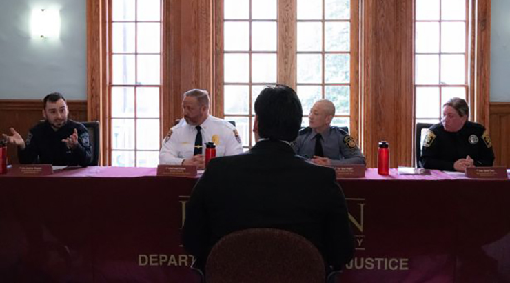 Officers sitting at panel table answering questions.