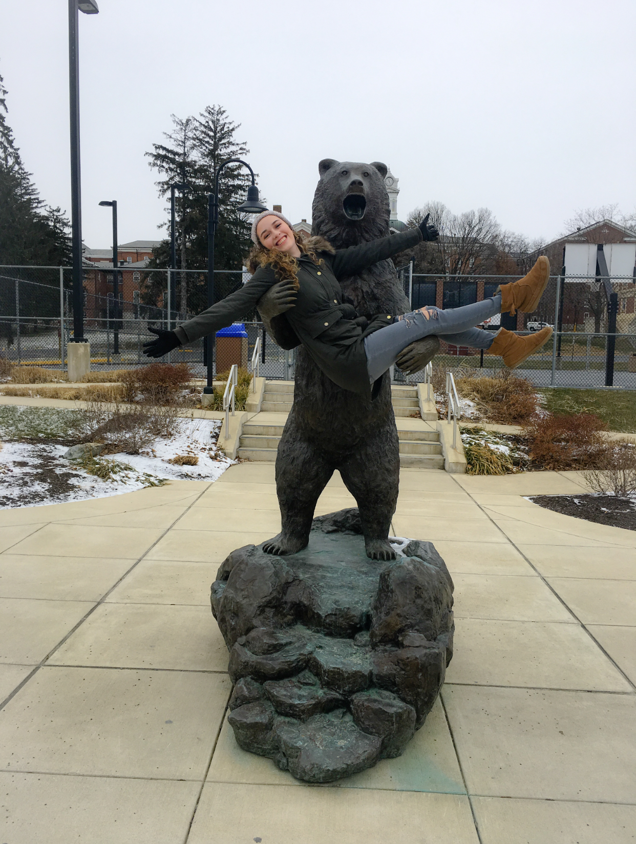 Karley Pedrick in the arms of the golden bear statue