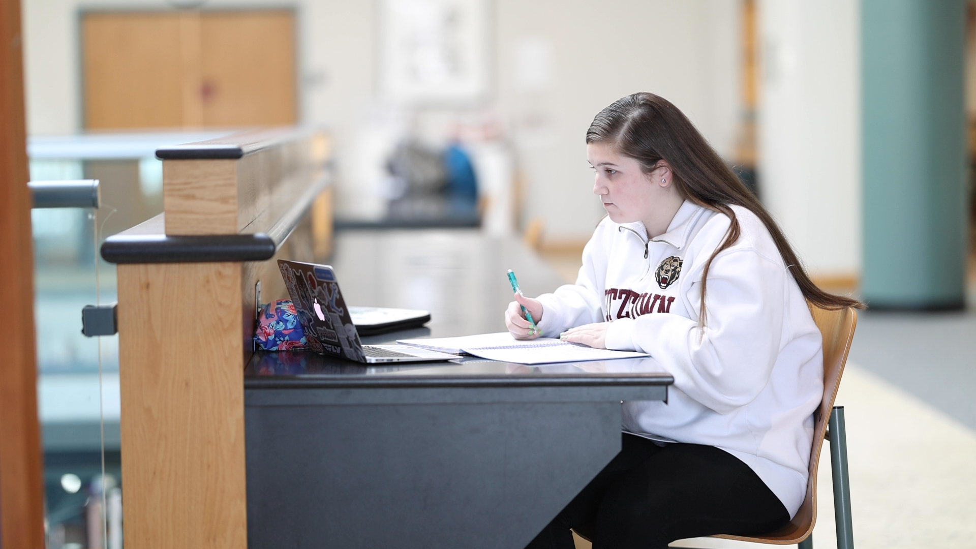 KU student working at a desk in the library