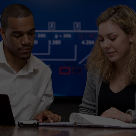 Black Male and Latino Female seated working on documents at a table