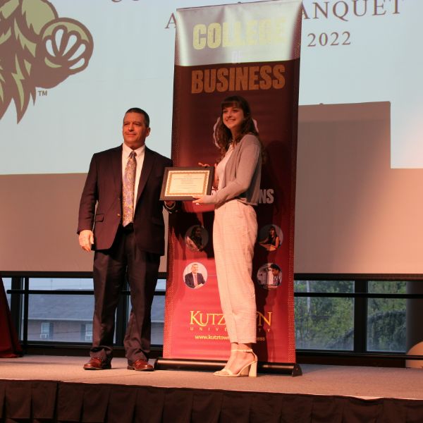 Jaclyn Rodick accepting her award from Dr. Riley on stage 