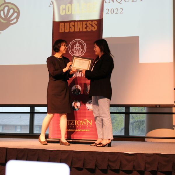 Tu Bang Huynh being presented her award on stage 