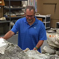 Dr. Ed Simpson admiring a large fossil specimen.