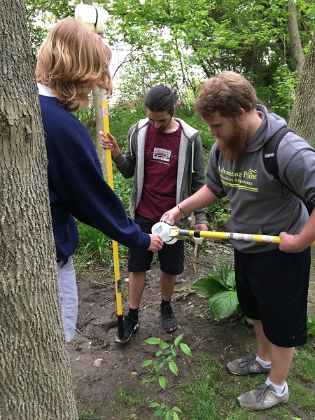 students collecting water with a yellow swing sampler