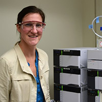 Dr. Julie Palkendo wearing safety goggles in a laboratory setting.