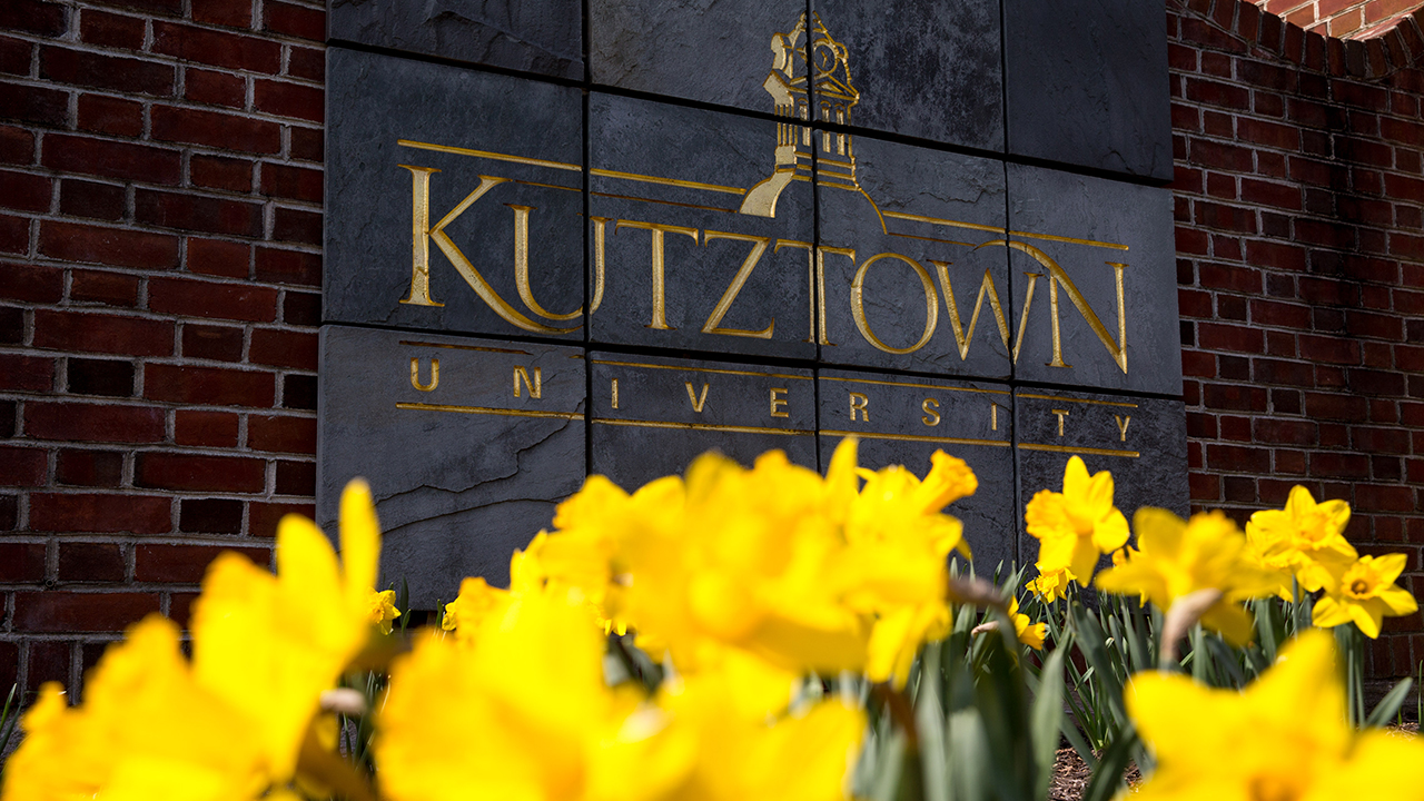 Kutztown University welcome sign with yellow flowers in the foreground