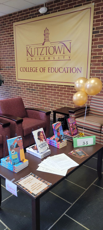 Books on display in front of banner that reads Kutztown University College of Education