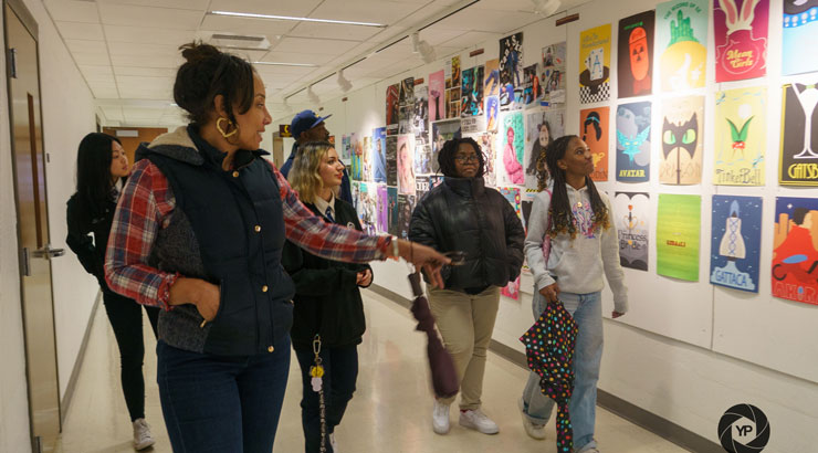 Students and faculty admire artwork on the walls.