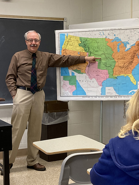 Dr. Michael Gabriel pointing to a large US map 