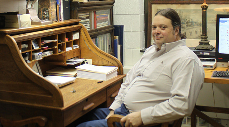 Dr. Reynolds sitting at his wooden desk