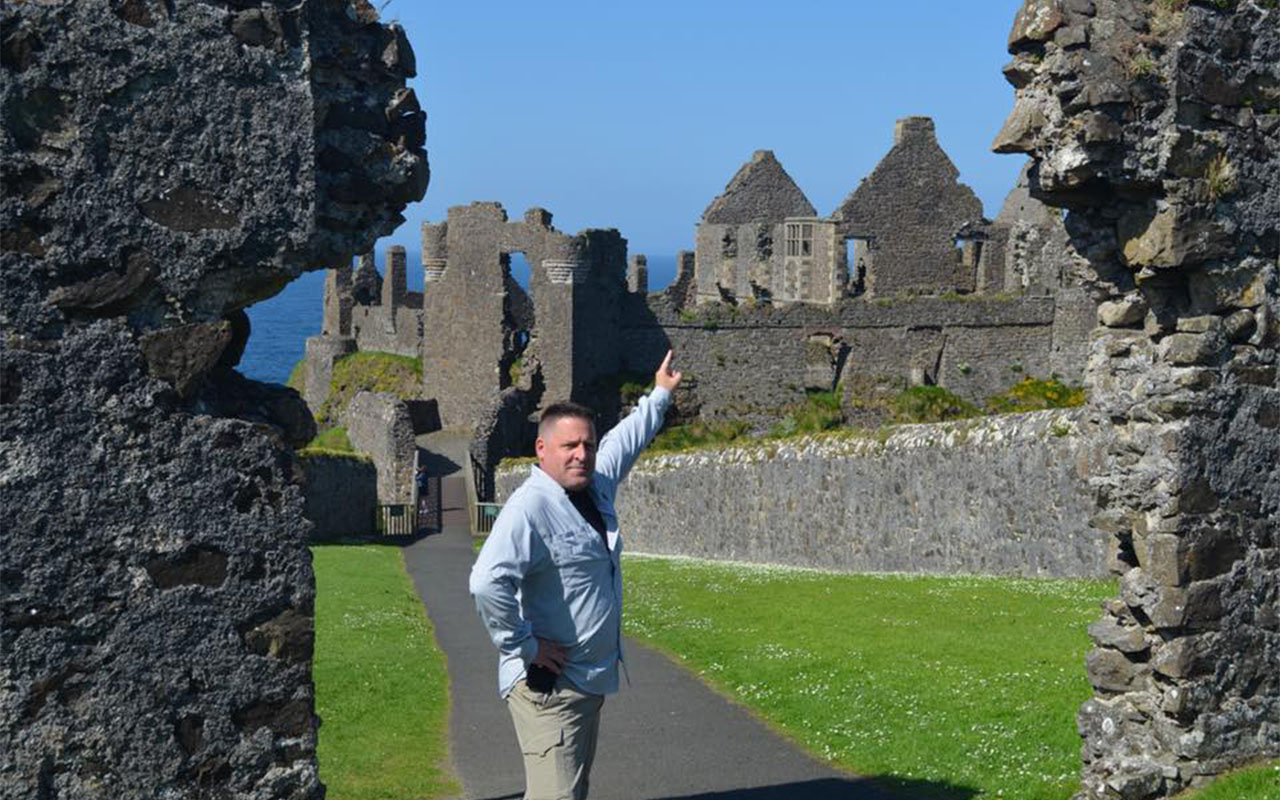 Dr. Johnson pointing to a castle ruin in Ireland