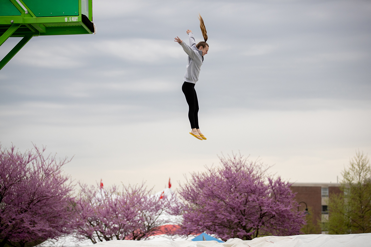 student jumping off of a platform into a giant cushion on the "stunt jump"