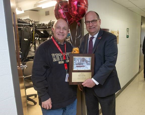 Edwin Landrock being presented the employee of the month placard by Dr. Hawkinson 
