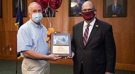 Dr. Hawkinson presenting William Lendzinski with the Employee of the Month award