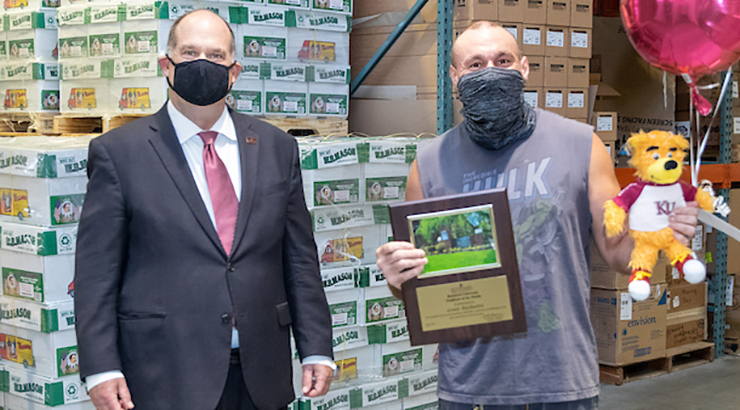  Louis Richuitti accepting his Employee of the Month placard and golden bear from Dr. Hawkinson in a KU storage facility 