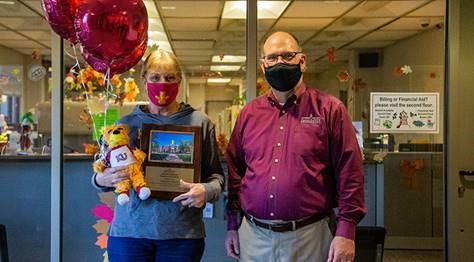 President Hawkinson presenting Tamara Shirk with her Employee of the Month award plaque and gifts 