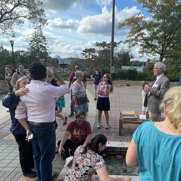 Faculty and staff cheer along the path of the 2023 1st Annual Duck Race.