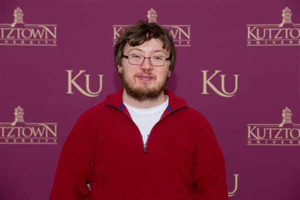 Jacob Christ standing in front of KU wallpaper