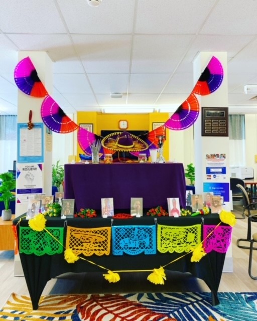 colorful display including table and banner for Dia de los Muertos