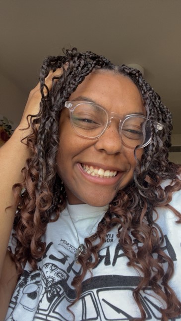 woman smiling with curly hair and glasses