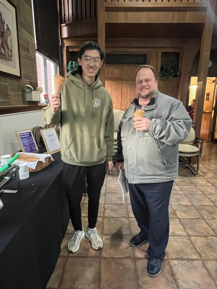 student and staff member holding ice cream cones smiling