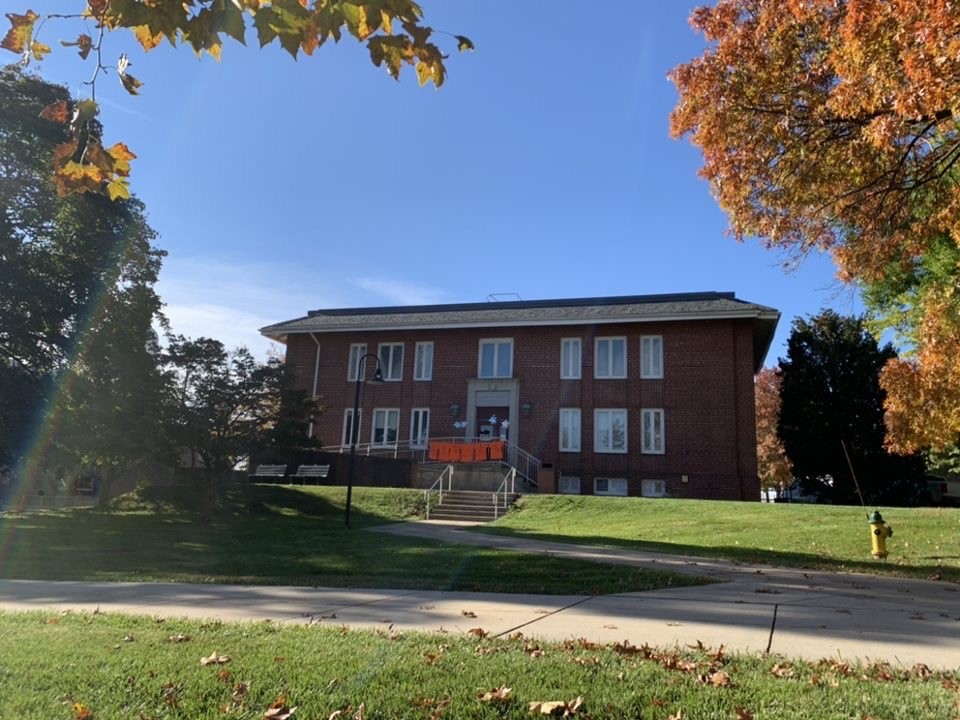 Exterior of the Multicultural Center. Sidewalk going up to steps/a ramp that leads to a large brick building.