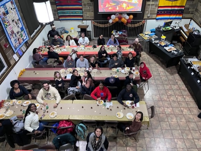 Many students at tables in MCC Unity Room looking up at camera. Picture taken from above.