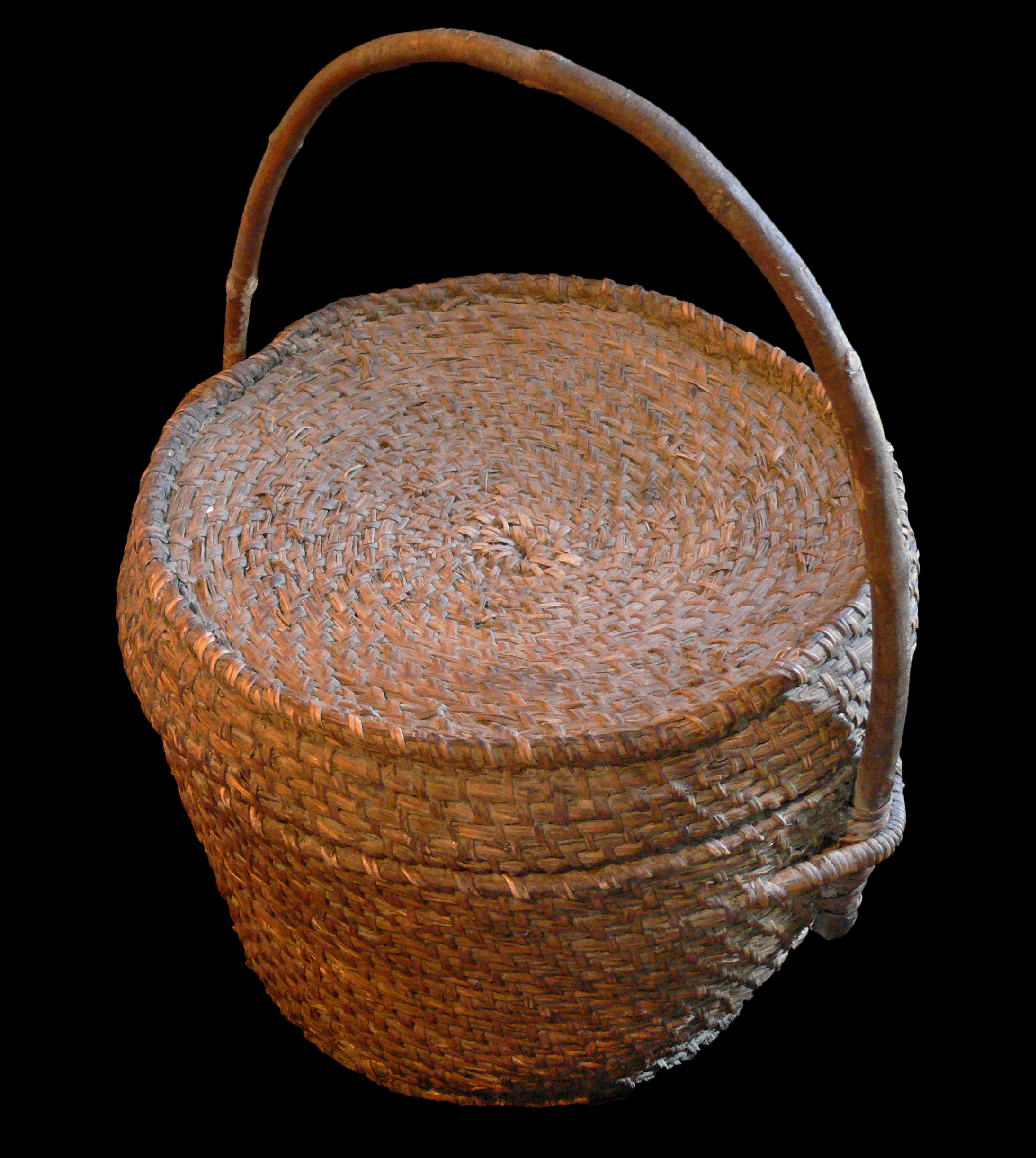 A woven wooden morel basket with a woven lid. There is an arched wooden handle attached to the sides.