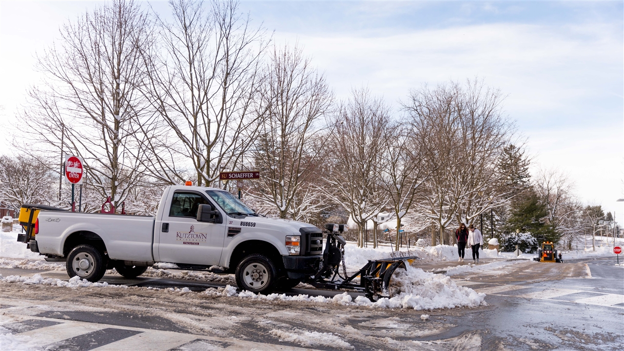 Kutztown University white plow truck, pushing snow off of Schaeffer Ln. 