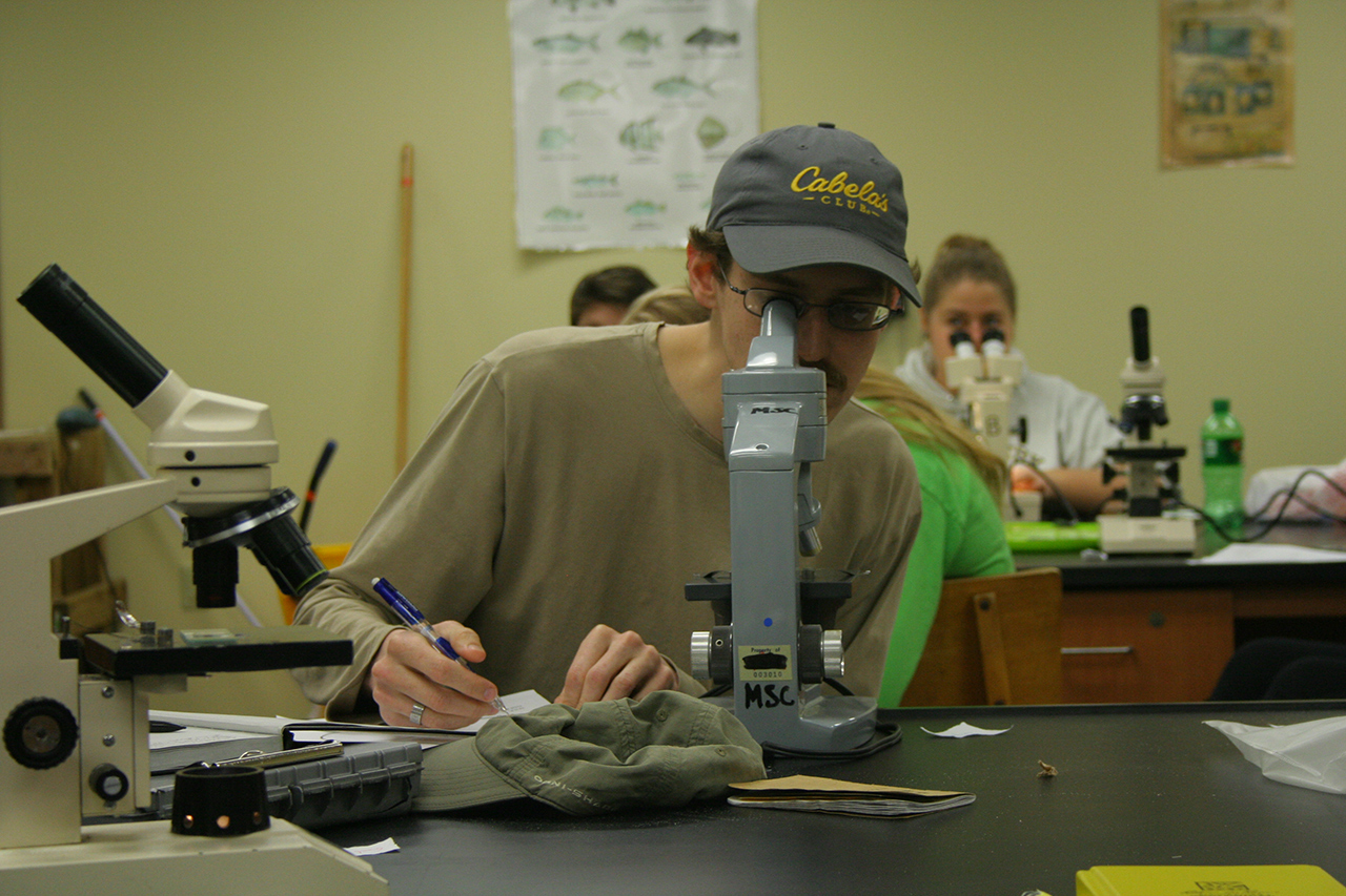 student at a microscope in the lab