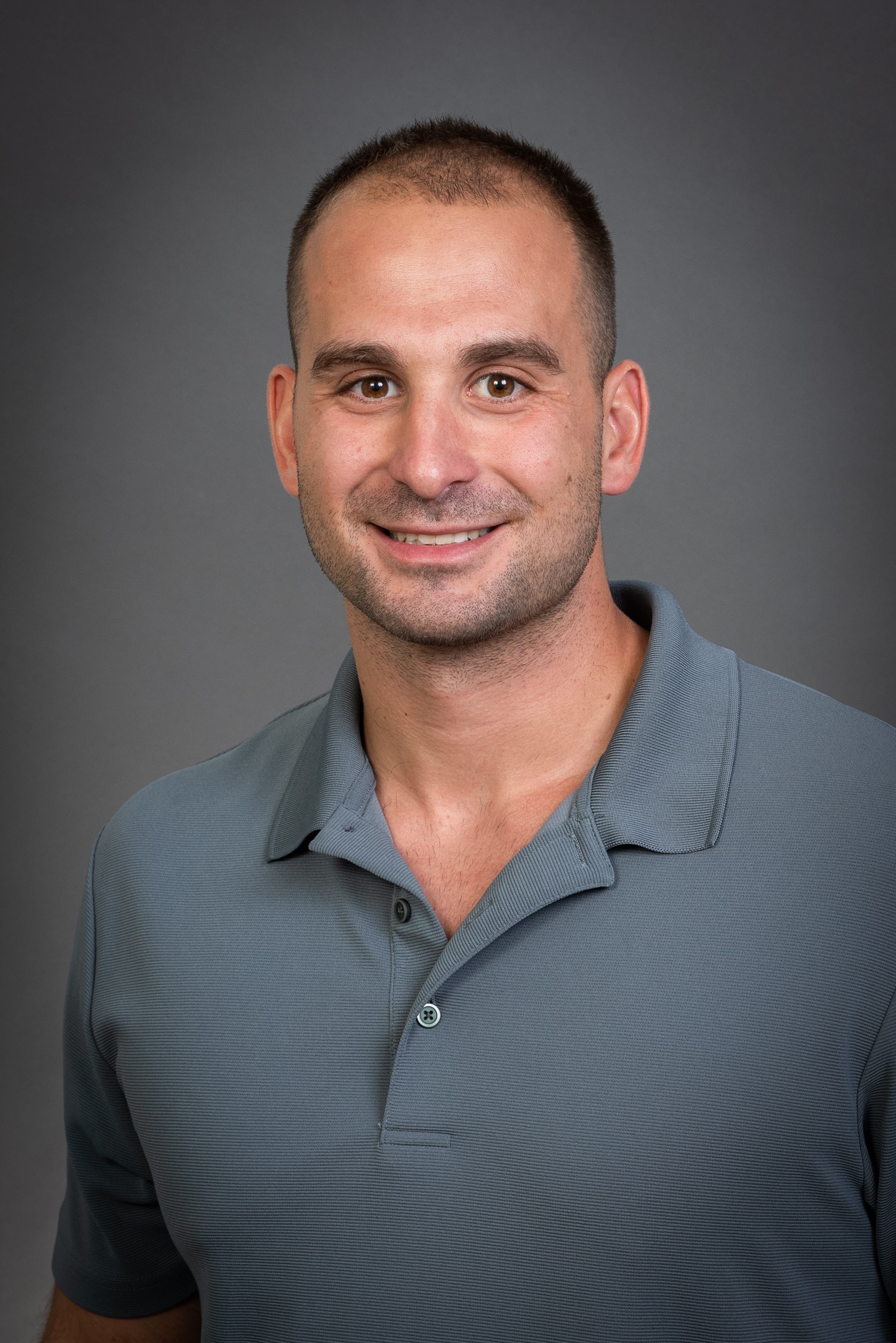 Head shot of Chris Alyanakian wearing a grey shirt