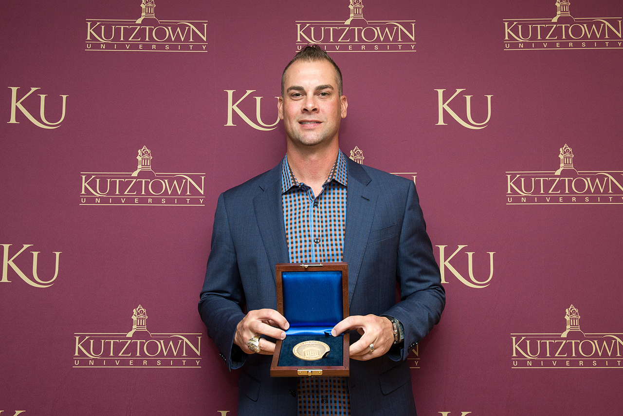 Ryan Vogelsong holding the Kutztown University President's Medal 