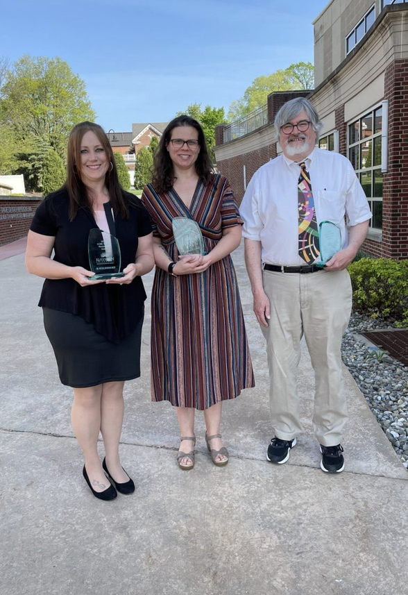 Under blue skies faculty mentorships award recipients, Dr. Johnson, Dr. Clemens, and Dr. Parson Clemens pose with their awards.