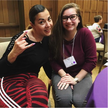 Female student Lauren Verna smiling next to female rap artist Reyhan Sahin, whose arm is around her