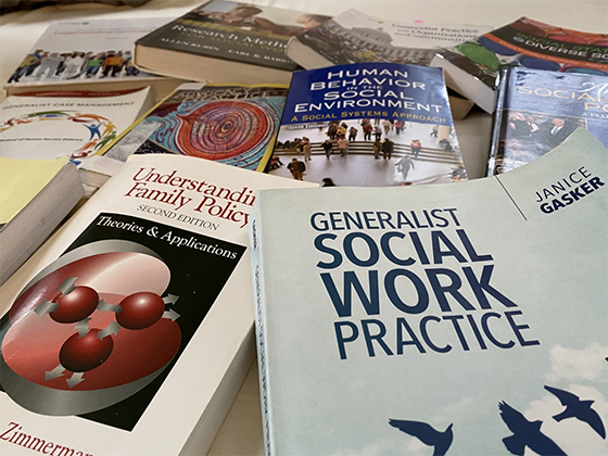 Social Work textbooks laid out on a table. 