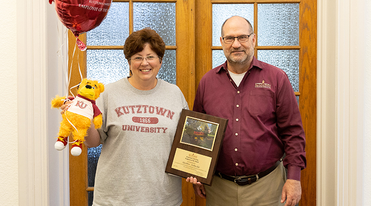 Arbuckle holding awards, standing next to President Hawkinson