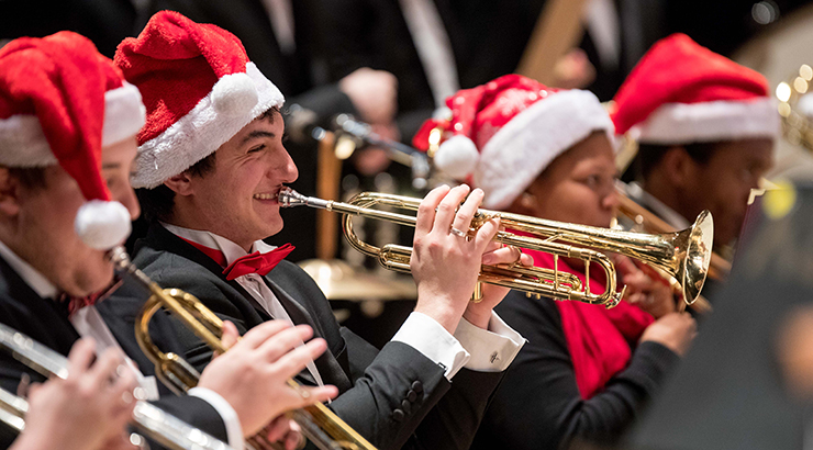 Student playing trumpet wearing holiday hat