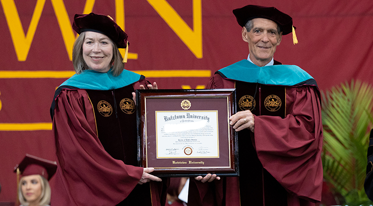 Recent honorary doctorate recipient, Sandra and Pat Corpora hold the honorary doctorate plaque.