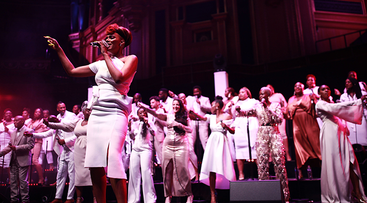 Singer on stage with choir behind.