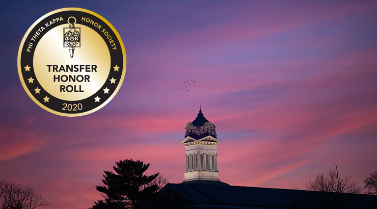 Distant shot of the Old Main clock tower during sunset, with an image of the Transfer Honors Award seal in the top left corner