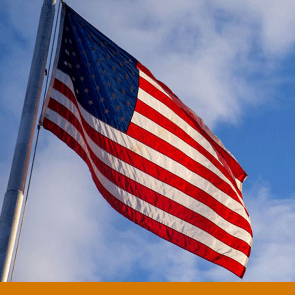 American Flag flying in front of a blue sky