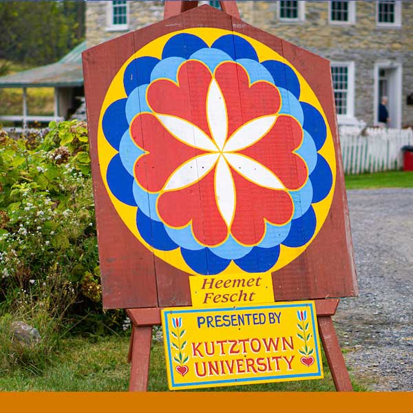 Heemet Fescht sign that has a large colorful barn star above the wording Heemet Fescht presented by Kutztown University