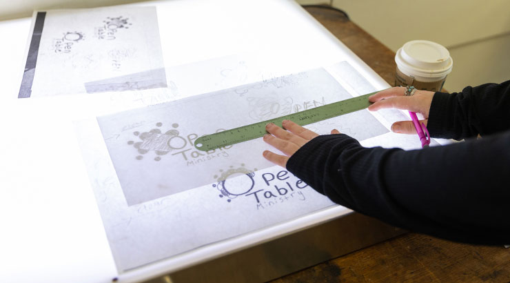 Kutztown University student using tracing table in graphic design studio.