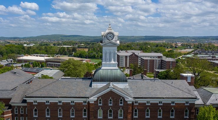 View of Old Main clock tower blue sky with white clouds