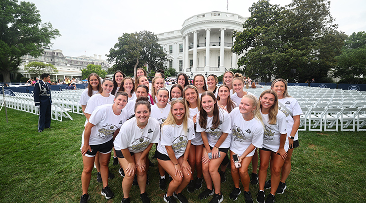 Team standing in a group with The White House in background