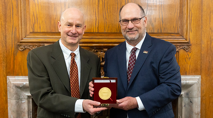 Jason Graver and President Hawkinson hold medal