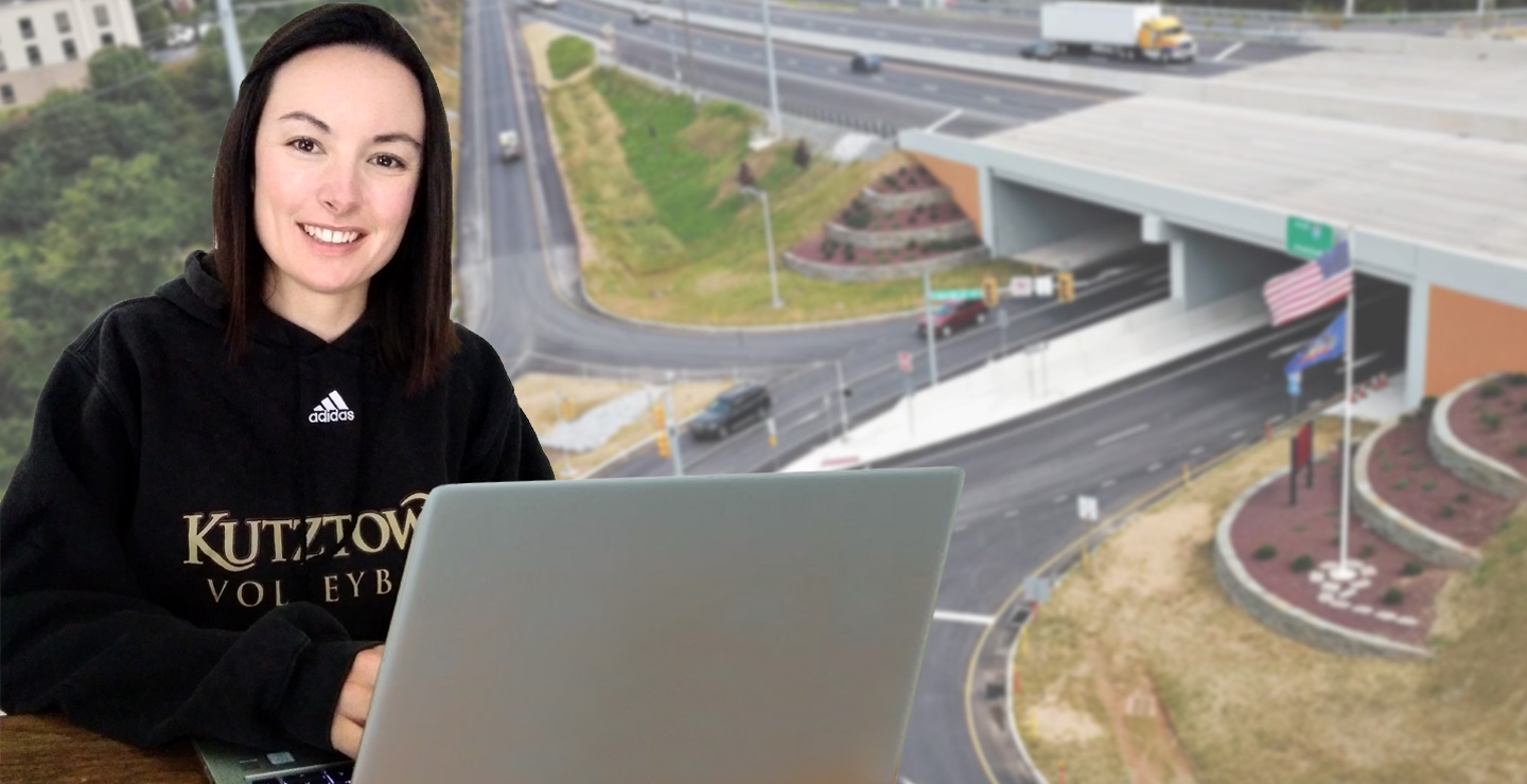 Erin waters, seated in front of a laptop computer.  She is wearing a black sweatshirt with the words Kutztown Volleyball across the front.  In the background, is an image of a highway interchange.