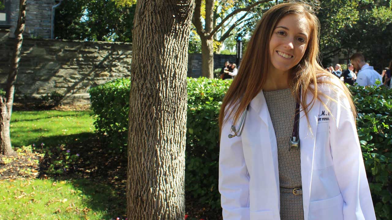 Biology/Pre-Medical graduate Alyssa poses in her doctor's lab coat.