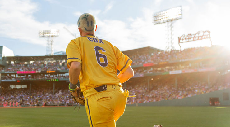 Kutztown University alumnus Ryan Cox wearing a bright yellow Savannah Banana's uniform with smiley faces dyed into his hair, runs into a stadium full of fans.