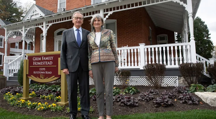Robert Grim Esq. and his wife Jane, stand outside the former home to generations of Grims on the campus of Kutztown University.